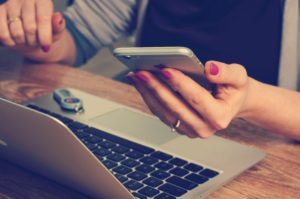 woman holding computer and iphone