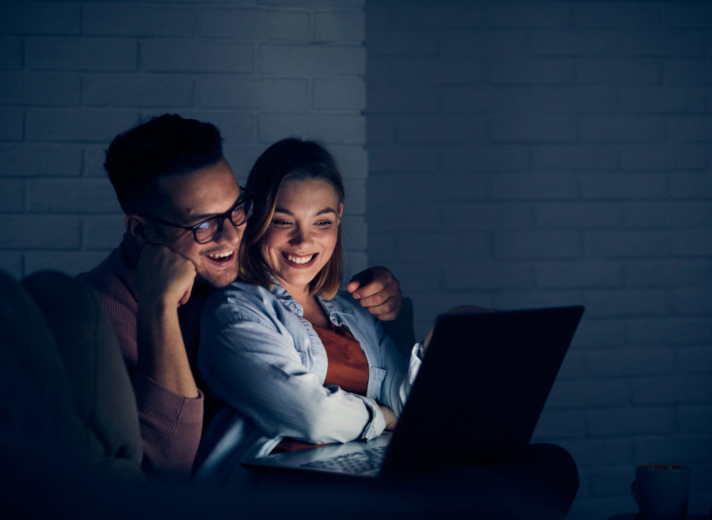 A couple watching free streaming service on laptop in living room