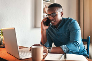 Man sitting at desk and calling Verizon customer service on his phone