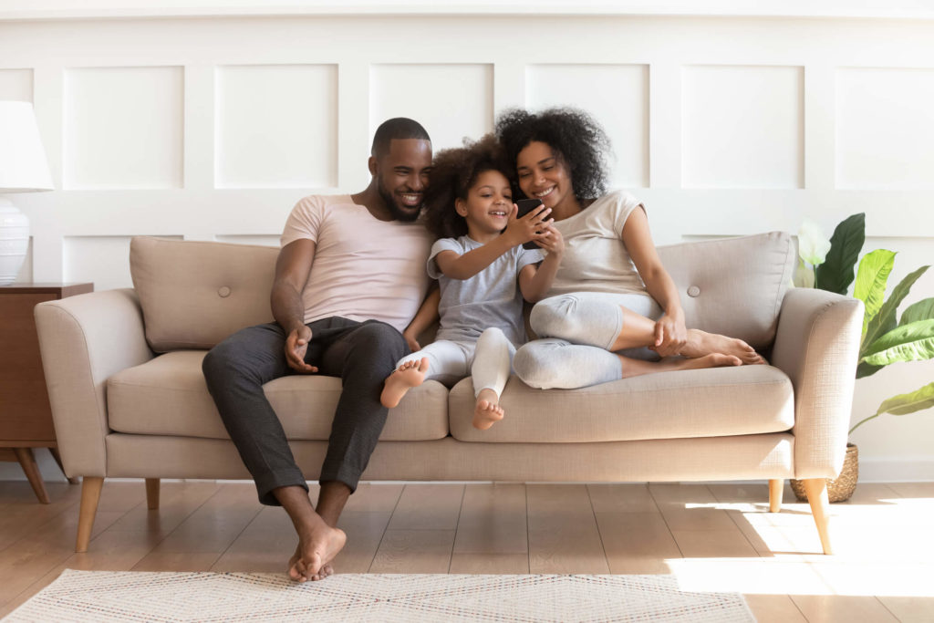 Small family sitting on couch together