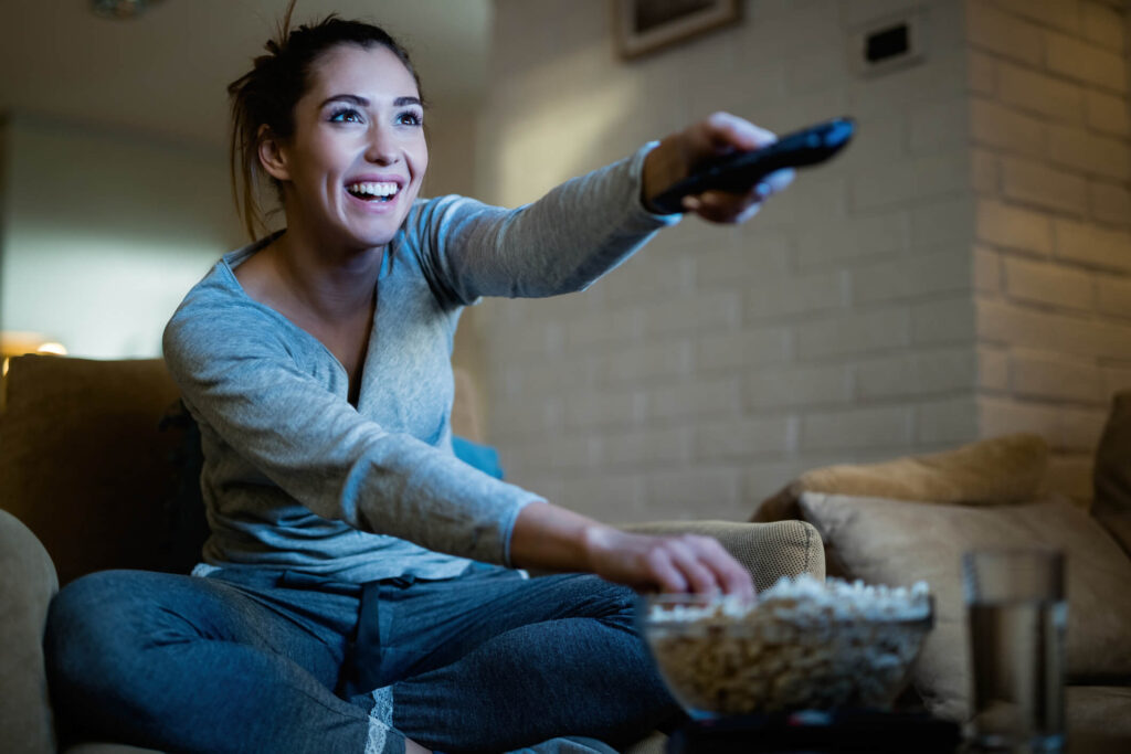 Woman on couch watching Amazon Fire TV