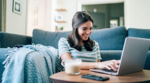 Beautiful Young Woman relaxing and surfing the net at home