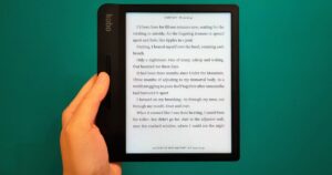 A woman holding a Kobo Libra H2O ereader