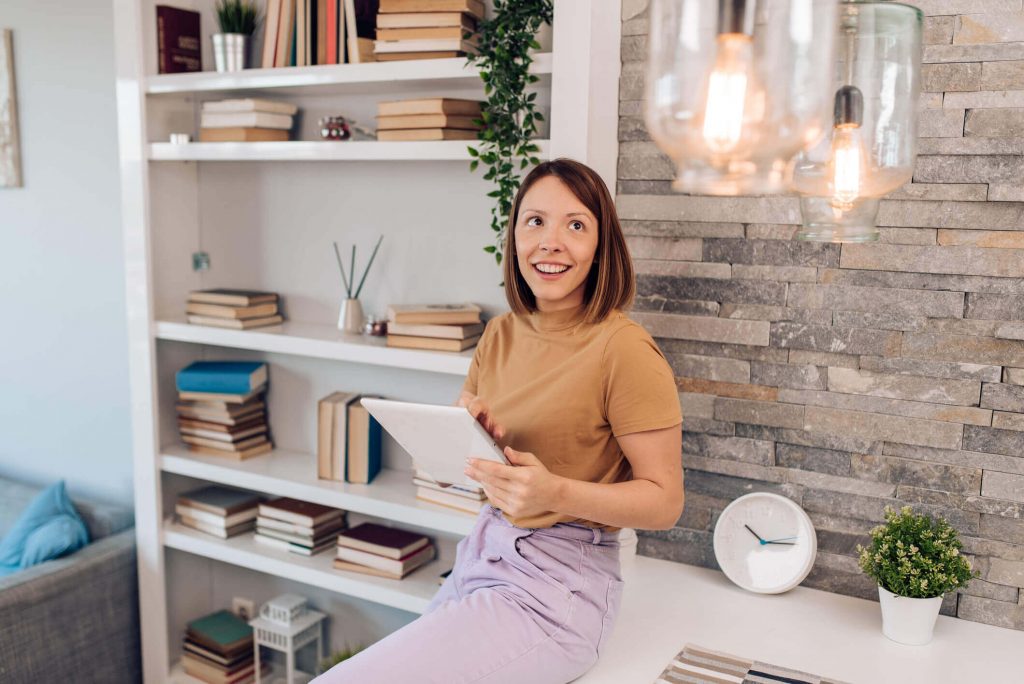 Woman using tablet and looking happy in modern-looking home