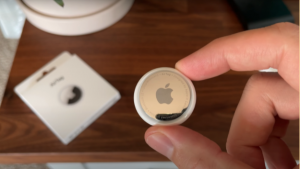 Image of one hand holding the Apple Airtag