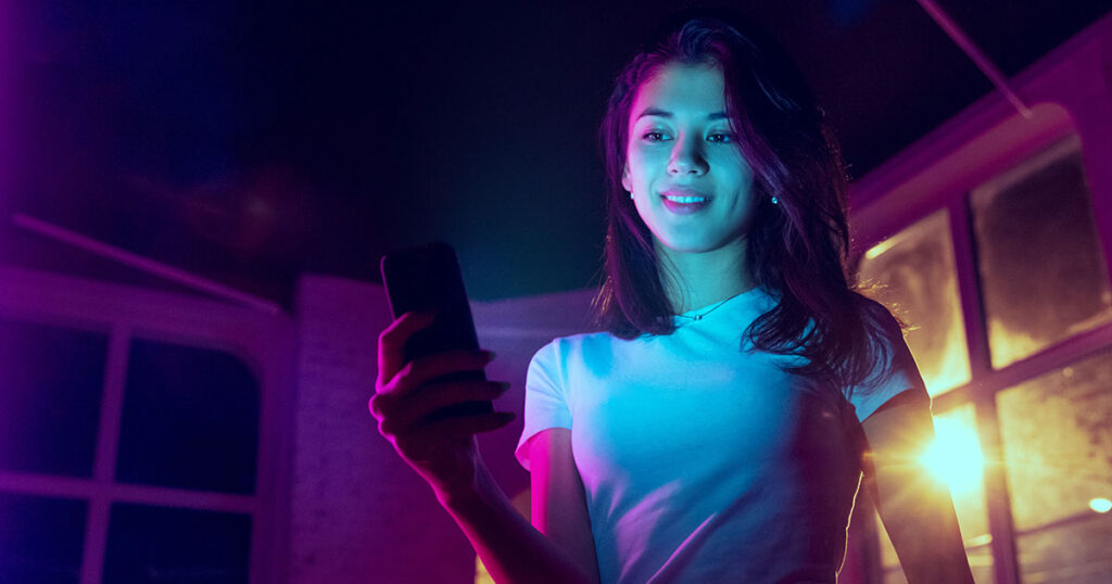 Photograph of a woman using her smartphone on the Optus mobile network