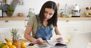 Stock photograph of a woman adding up her internet bills