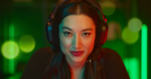 young brunette woman wearing the Corsair HS80 wireless gaming headset with green lighting surrounding her