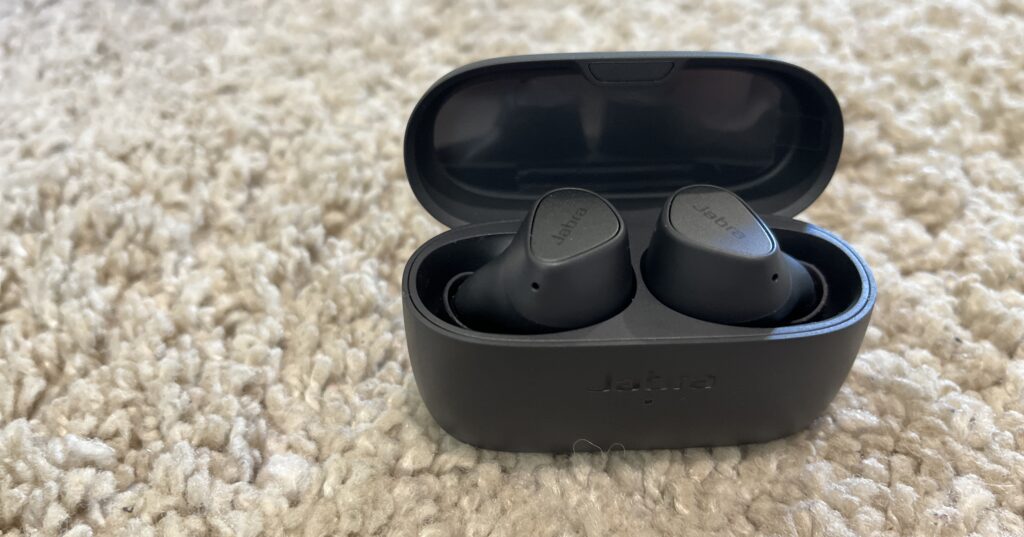 Jabra Elite 3 wireless earbuds on a beige rug