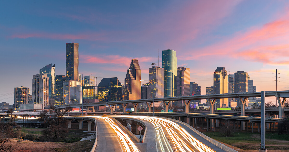 A view of the Houston, Texas downtown skyline with highways in the foreground and skyscrapers in the background.