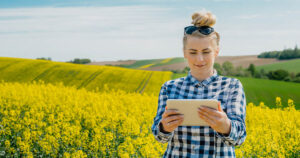 Photograph of a woman in a field using her tablet on Fixed Wireless NBN