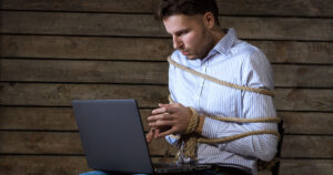 Photograph of a man tied up using the computer