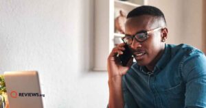 Man sitting at desk and calling Verizon customer service on his phone