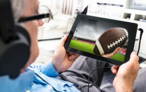 man watching football on table while wearing headphones