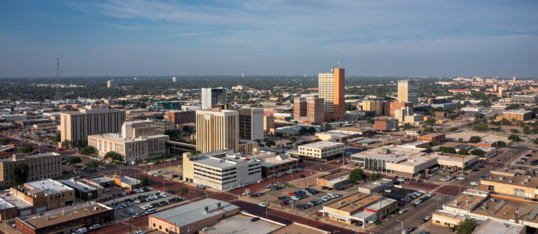 Downtown Lubbock, Texas, is shown from an aerial view on a summer morning. Texas Tech University is in the distant background.