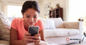 young girl using cell phone on couch