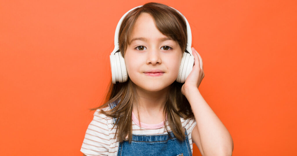 Little girl wearing white headphones designed for kids