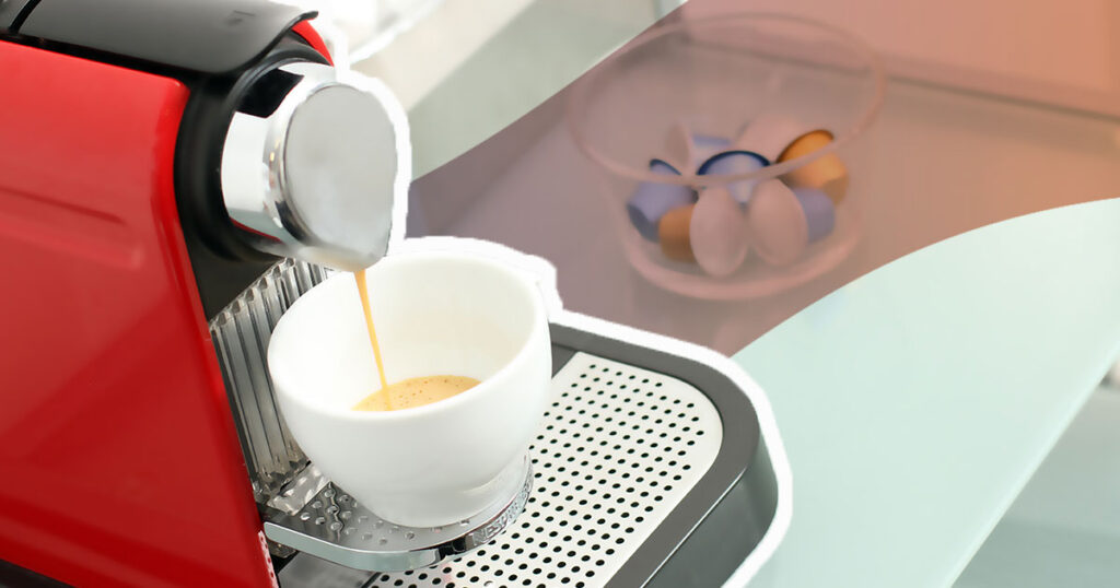 red nespresso machine pouring espresso in to a white cup with a bowl of classic pods in the background
