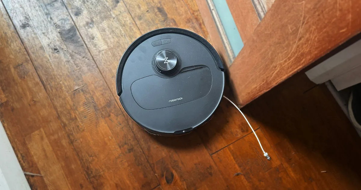 qrevo master from above on a wooden floor with a cable sticking out of it